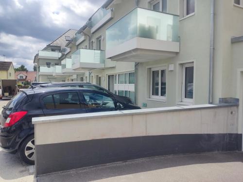 a car parked in front of a building at Harmonie Homes - Built in 2025 - Hotel-Quality Beds & Linen - Full Kitchen - Fiber WiFi - 4K Smart TV - 2 Balconies - Elevator - Free Private Parking - Near Augsburg - 20 Min via Autobahn to Munich-West in Dasing