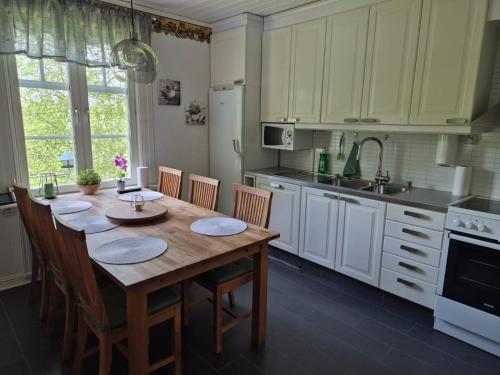 a kitchen with a wooden table with chairs and a sink at Ferienhaus mit viel Charme in Lunde