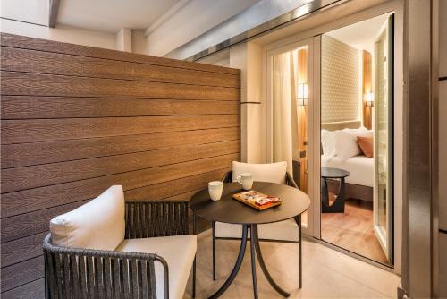 a room with a table and chairs and a bedroom at Catalonia Plaza España Hotel & Spa in Madrid