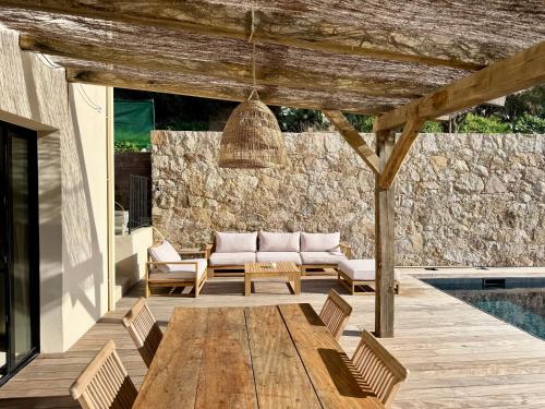 a patio with a wooden table and chairs next to a pool at Villa Casa Savelli in Corbara
