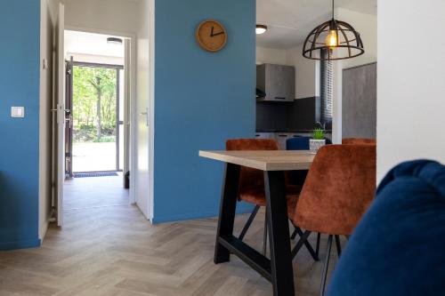 a kitchen and dining room with a table and chairs at Vacation house with sunny garden near lake in Ewijk