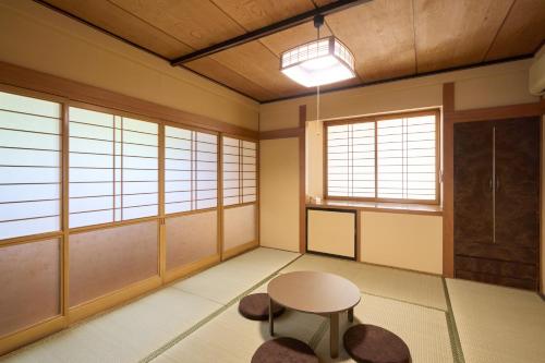 a room with a table and chairs and windows at Vacation Rental 八庵 HACHIAN in Hachinohe