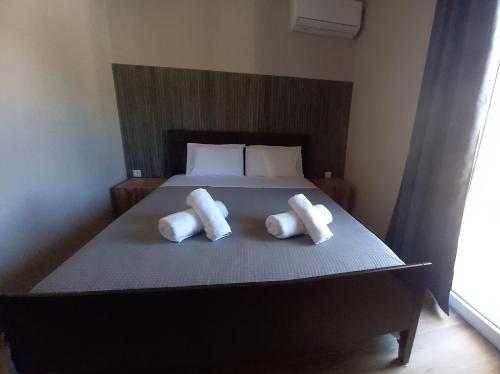 a bed with two pillows on top of it at Akrata Green Elite Apartments in Akrata