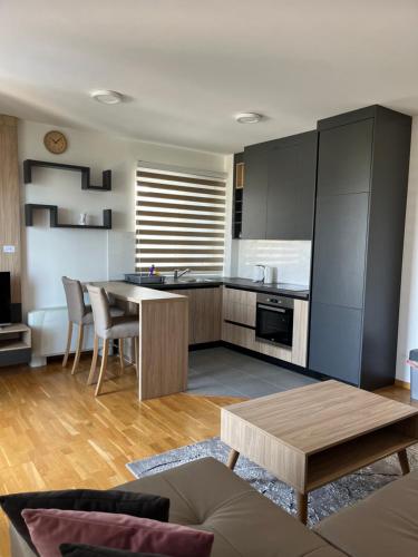 a living room with a table and a kitchen at Ilidža Tower Sapphire Suites in Sarajevo