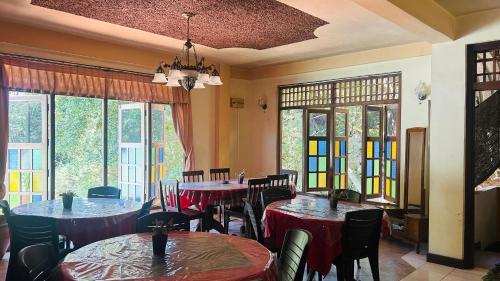 a dining room with tables and chairs and windows at Anniwatta Residence in Kandy