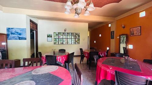 a restaurant with tables and chairs with red table cloth at Anniwatta Residence in Kandy