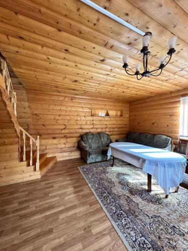 a living room with a bed in a wooden room at Деревяшка in Kara-Oy