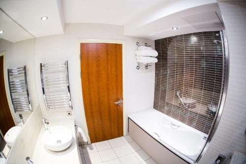 ein Badezimmer mit einem Waschbecken, einem WC und einem Spiegel in der Unterkunft Drayton Manor Hotel in Tamworth
