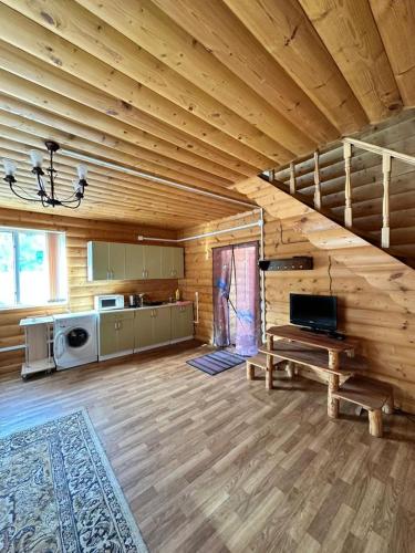 a living room with a staircase in a log cabin at Деревяшка in Kara-Oy
