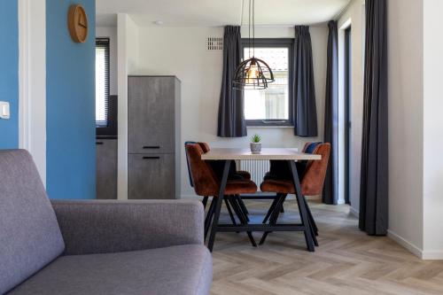 a living room with a dining room table and a couch at Vacation house with sunny garden near lake in Ewijk