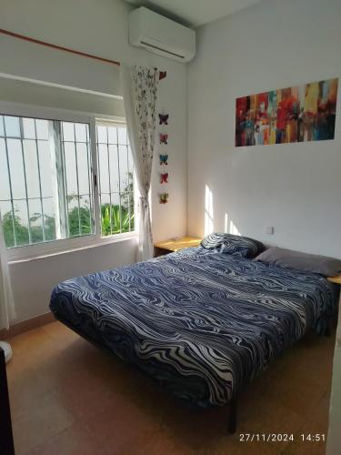 a bedroom with a bed in a room with windows at Relax Ferrandiz in Málaga