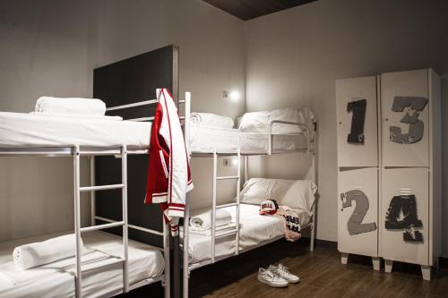 a dorm room with three bunk beds and a locker at room00 Chueca Hostel in Madrid