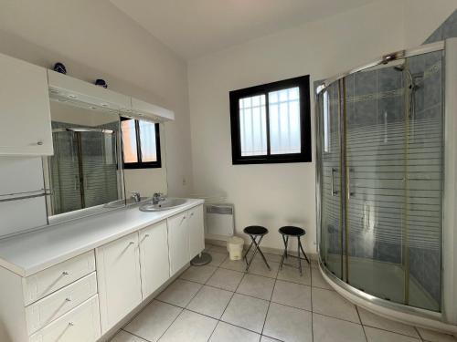 La salle de bains est pourvue d'une douche et de deux tabourets. dans l'établissement VUE MER Maison individuelle 30 m de la plage 4 chambres 10 couchages jardin parking LXRM26, à Portiragnes