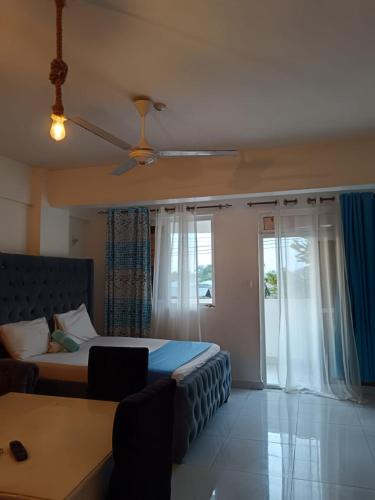 Un dormitorio con una cama y una ventana en 5 Minutes to the Beach - Studio, en Mombasa