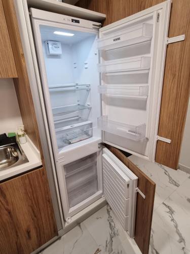 an empty refrigerator with its door open in a kitchen at Maryah Vista in Abu Dhabi