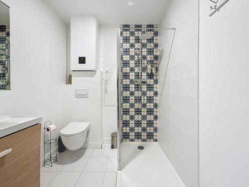 ein weißes Badezimmer mit Dusche und Toilette in der Unterkunft L'Alcazar - Appartement à deux pas des halles - Climatisation in Narbonne