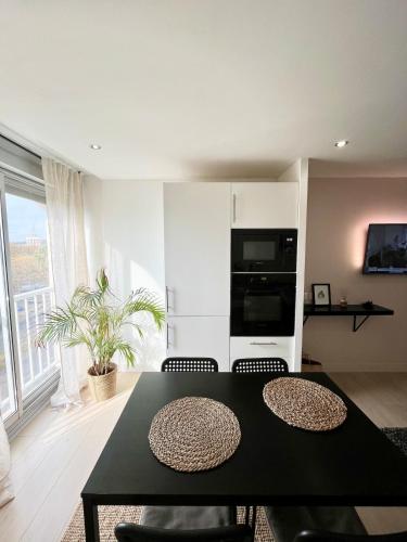 un salon avec une table et des chaises noires dans l'établissement Charmant Appartement T2 à deux pas de la Mer, au Cap d'Agde
