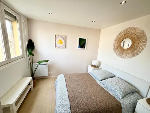 une chambre avec un lit et un miroir au mur dans l'établissement Charmant Appartement T2 à deux pas de la Mer, au Cap d'Agde