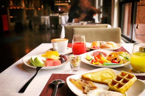 a table with plates of breakfast food and drinks at Grand Victoria Hotel in Taipei