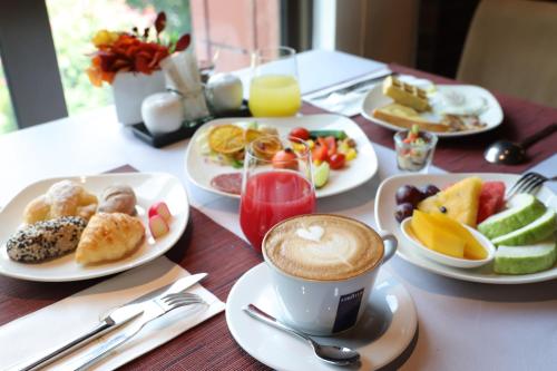 a table with plates of food and a cup of coffee at Grand Victoria Hotel in Taipei