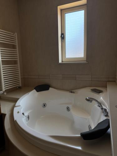 a bath tub in a bathroom with a window at Maison Andre in Pano Lefkara