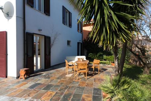 a patio with a table and chairs next to a building at Guest House Le Acacie in Spoltore