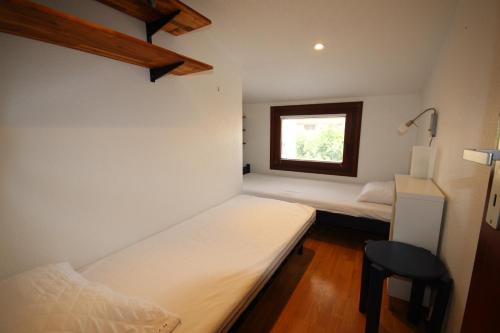 une petite chambre avec deux lits et une fenêtre dans l'établissement Belle villa d'angle spacieuse climatisée, de tout confort dans domaine PORTES DU SOLEIL, ACCES PISCINES PAYANT EN SUPPL - 3 chambres, 6 couchages, wifi, 400m de la mer LRPDSJ7, à Portiragnes