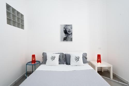 ヴィーコ・エクエンセにあるMarisabella luxury homeのベッドルーム1室(白いベッド1台、赤いランプ2つ付)