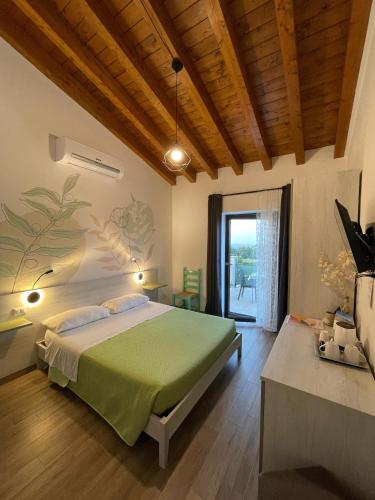 a bedroom with a bed with a green bedspread at Agriturismo Casale Lisalola in Sutri