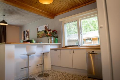 a kitchen with white cabinets and a window at Boerenvakantie in Hilversum