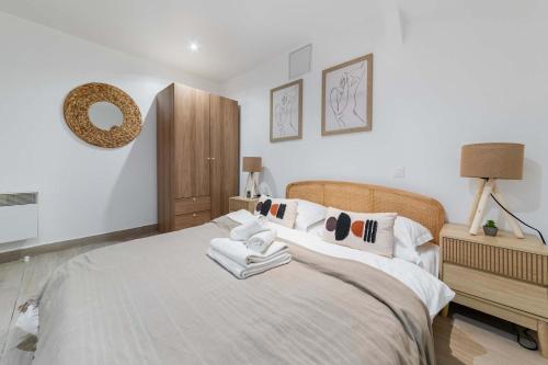 a bedroom with a large bed with towels on it at Appartement neuf 40m2 aux lilas - 4P - FLAT-GUEST in Les Lilas