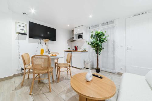 une cuisine et un salon avec une table et des chaises dans l'établissement Appartement neuf 40m2 aux lilas - 4P - FLAT-GUEST, aux Lilas