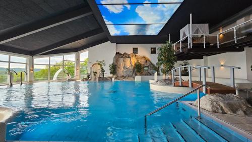 a large swimming pool in a hotel with a large window at Göbels Hotel Rodenberg in Rotenburg an der Fulda