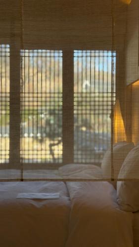 a bedroom with a bed and a large window at Hyowudang in Gyeongju
