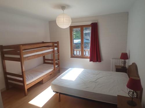 ein Schlafzimmer mit Etagenbett und Fenster in der Unterkunft Le fleuri ensoleillé de Guzet in Ustou