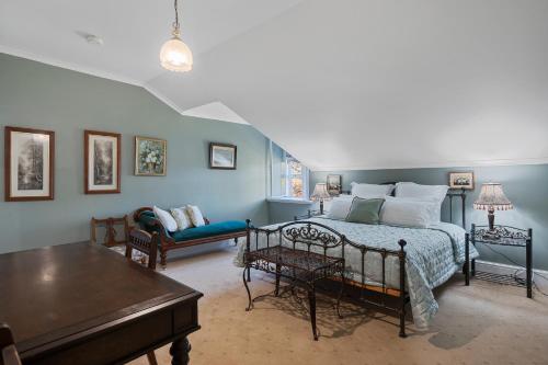 a bedroom with a bed and a couch at Rose Room, Franklin Lodge, Huon Valley in Franklin