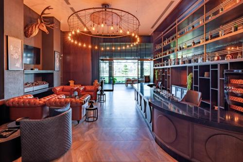 a restaurant with a bar with leather chairs and a chandelier at Ethno Belek in Belek