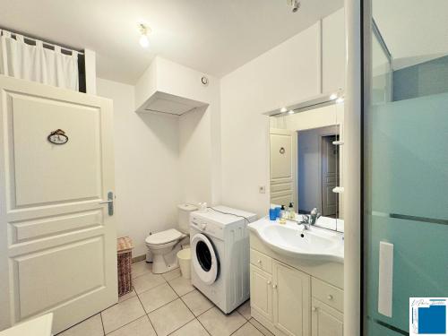 une salle de bain avec une machine à laver et un lavabo dans l'établissement Villa Nepita-climatisation-1chb- piscine, à Lecci