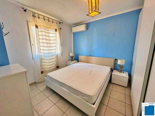 une chambre avec un lit et un mur bleu dans l'établissement Villa Nepita-climatisation-1chb- piscine, à Lecci