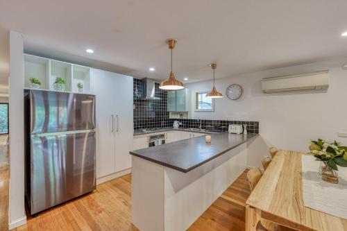 a large kitchen with a stainless steel refrigerator at Acacia Rise - The Ultimate Peninsula Getaway in Cape Schanck