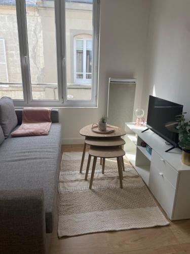 un salon avec un canapé et une table dans l'établissement Appartement 100 m de la plage, à Langrune-sur-Mer