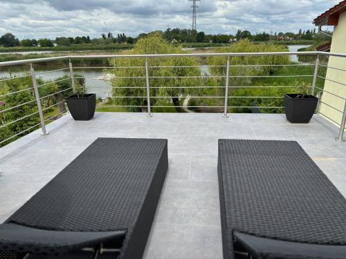 two benches on a balcony with a view of a river at RSD Riverside 