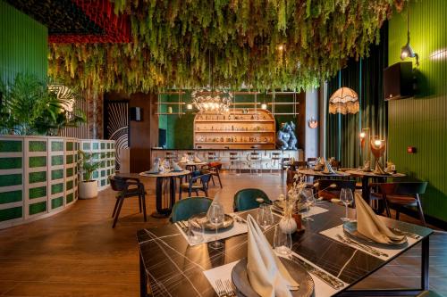a restaurant with tables and chairs and plants at Ethno Belek in Belek