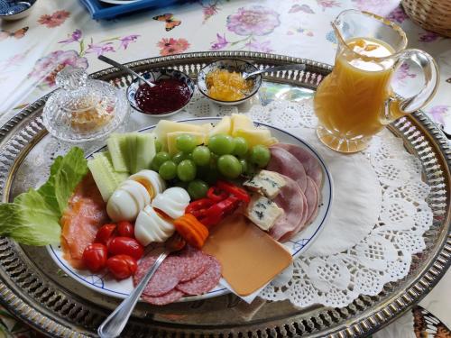 een bord eten met groenten en kaas en een drankje bij Leka Overnatting in Solsem