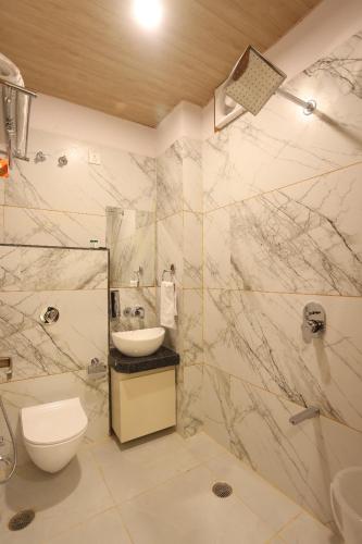 a bathroom with a sink and a toilet and a shower at hotel pride & restaurant in Dabok