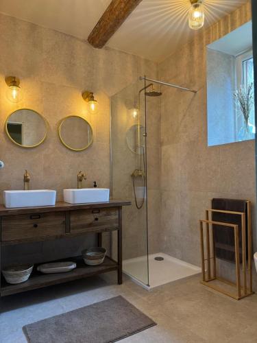La salle de bains est pourvue de 2 lavabos et d'une douche avec miroirs. dans l'établissement Les Romarins, à Lauris
