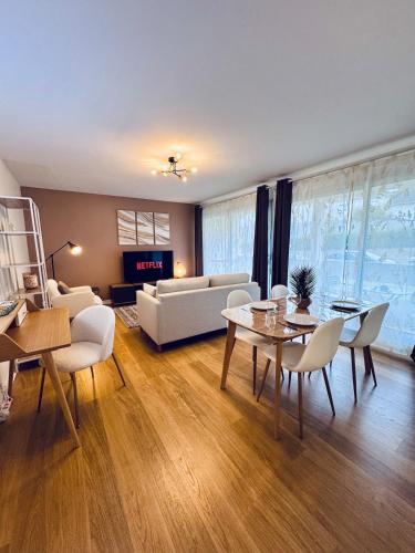 un salon avec un canapé, une table et des chaises dans l'établissement Refuge moderne à Quimper avec lit King Size, à Quimper