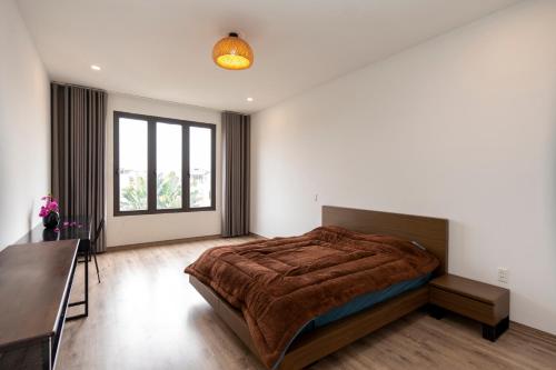 Un dormitorio con una cama grande y una mesa. en Cozy Embassy Garden, en An Dương