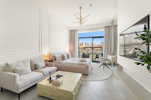 a living room with white furniture and a large window at FIRST CLASS Studio Luxe & Cozy Vibes in Dubai