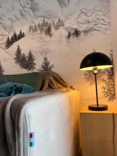 een lamp op een nachtkastje naast een bed bij Chalet 4 pers confort 100mdespistes St Lary 4 étoiles in Saint-Lary-Soulan
